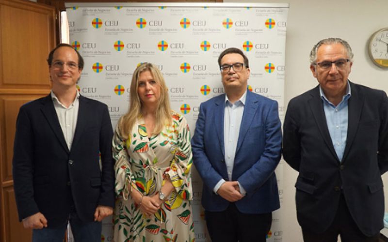 Foto de cuatro personas con el fondo del logotipo de escuela de negocios CEU Foto de cuatro personas con el fondo del logotipo de escuela de negocios CEU